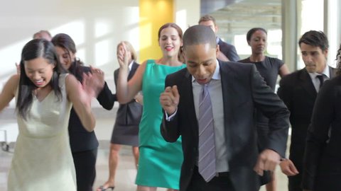 Businesspeople dancing in lobby as part of team building exercise.Shot on Canon 5DMkII at a frame rate of 25fps