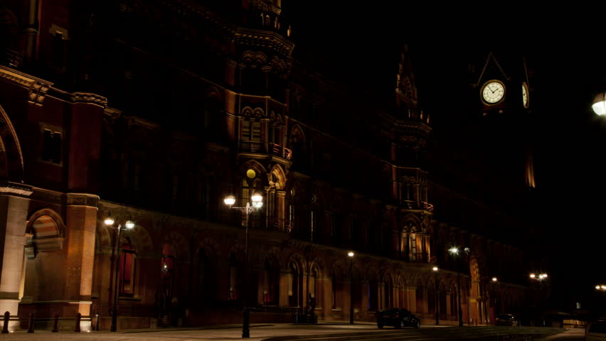 St Pancras railway station at night time lapse. Gothic fascia of the central London railway station at night. Wide and close up of the clock. 4K version