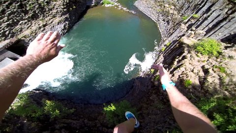 Extremely High POV Cliff Jump into Water above a Waterfall Trees and Rocks Below on a Beautiful Sunny Day in Summer in the Forest with a Thumbs Up to Bystanders Extreme Fun Point of View Head Camera
