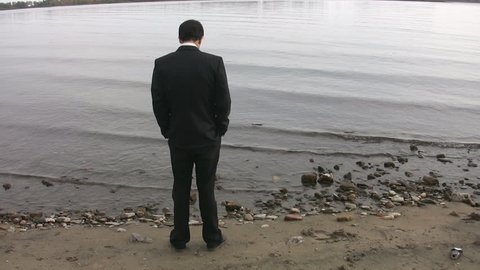 Businessman by the lake. Good shot to represent unemployment.