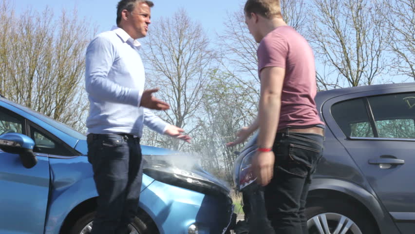 Two drivers argue about blame for accident by the side of damaged and smoking vehicles.Shot on Canon 5d Mk2 with a frame rate of 30fps