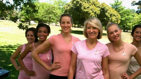 Group of women wearing pink for breast cancer in the park in slow motion