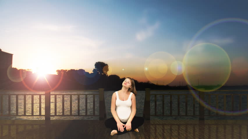 Pregnant woman exercising city skyline at sunset