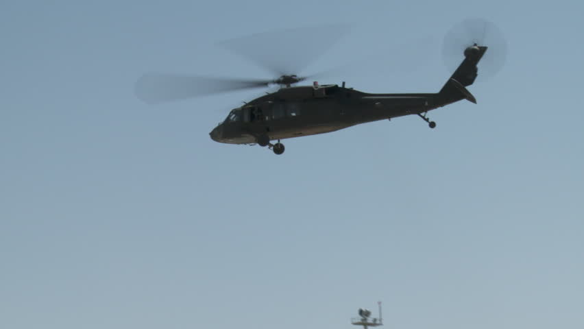 Blackhawk Helicopter Flies Past and Over Building