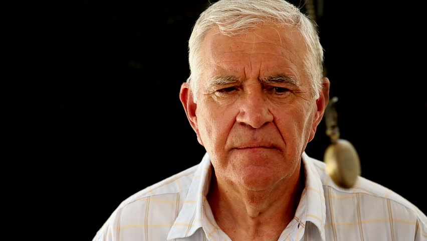 Senior man being hypnotized against a black wall