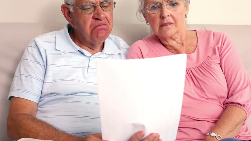 Worried senior Caucasian couple reading a document at home in the living room Royalty-Free Stock Footage #5908265