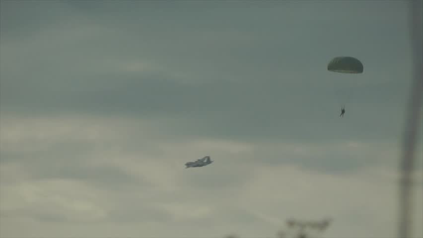 Air drop of paratroopers from C-130 Hercules airplane during a military training exercise.