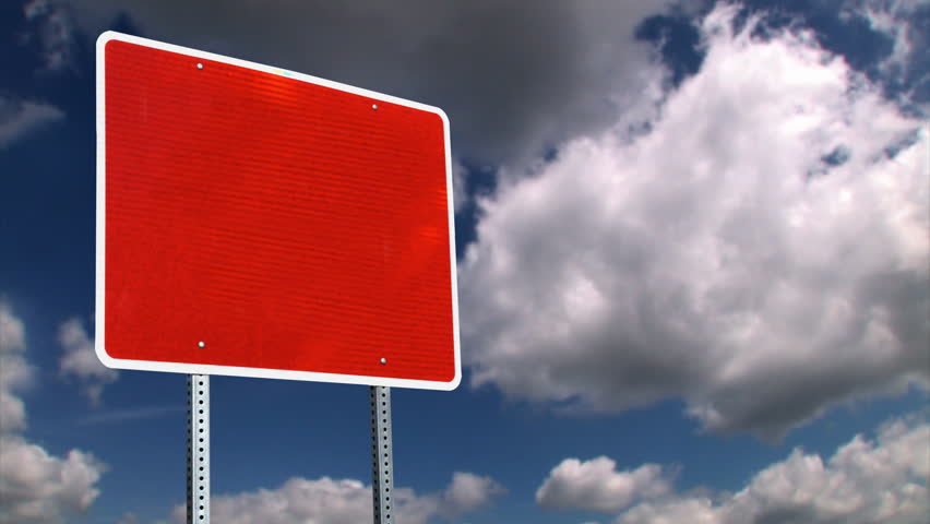 A red blank road sign with time lapse clouds.