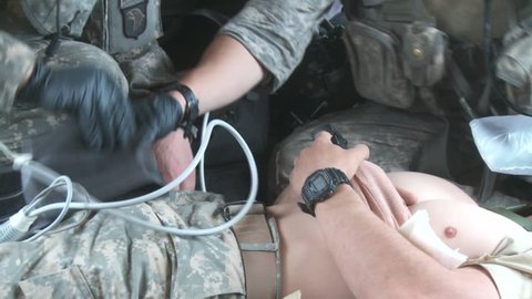 Afghanistan, Circa 2008: Army medics in a helicopter place blood pressure device on a wounded soldier in a medical evacuation in Afghanistan, Circa 2008