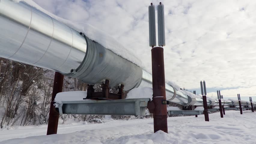 Oil pipeline with clouds moving across Alaskan Sky. Clouds move across a beautiful blue sky in Alaska with a silver pipeline in the forefront. Royalty-Free Stock Footage #5912450