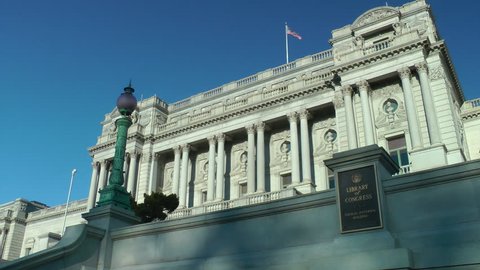 WASHINGTON, DC - MARCH 15, 2014:  Library of Congress, with sign, American flag waving, Jefferson Building, just across the street from the Capitol.