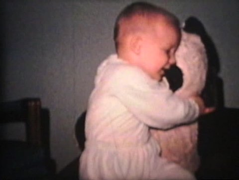 A cute little boy hugs his big Panda bear.