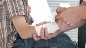 Male doctor examining kid's wrist. The patient is with his father. Footage in high definition. - Powered by Shutterstock - Get 15% off with code: PIKWIZARD15