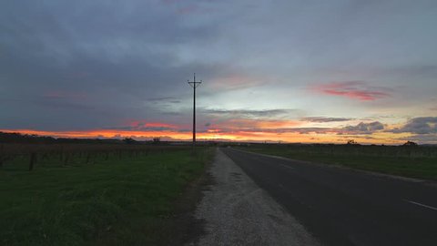 CIRCA JUNE 2013 - ADELAIDE , AUSTRALIA - golden sunset time lapse down the road in barossa valley with moving clouds