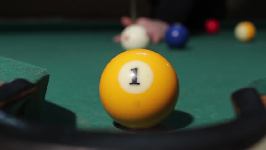 American billiard, 9-ball, nine-ball pool. Man playing billiard, snooker. Player preparing to shoot, hitting the cue ball and she hit yellow ball. Ball No.1 into the hole.Ball goes through the hole. Royalty-Free Stock Footage #5924600