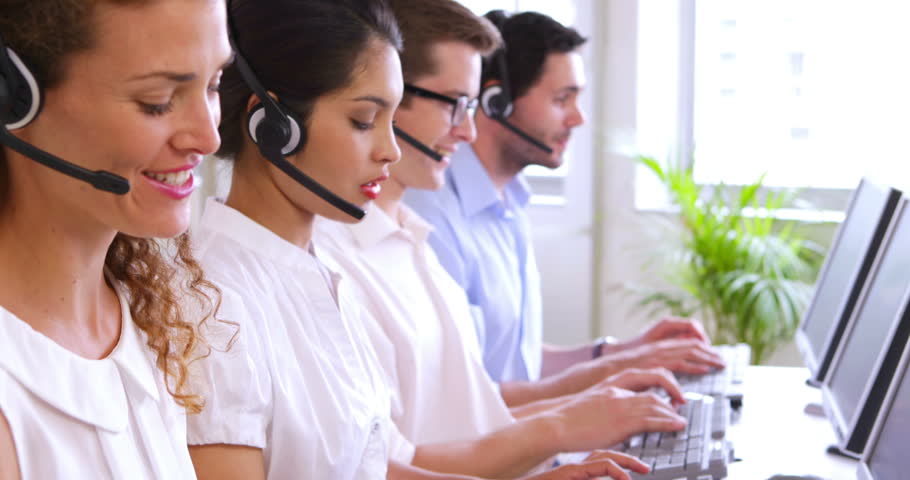Row of call centre agents typing at their desk in the office Royalty-Free Stock Footage #5935388