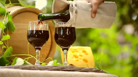 Wine. Red Wine and Cheese. Romantic Lunch Outdoor. Pouring Wine close-up. Outdoors 