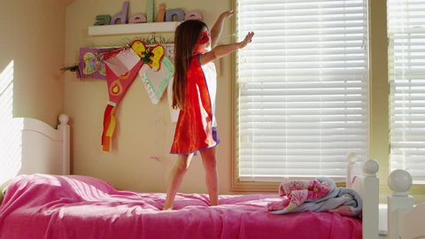 Young girl dressed as superheroes playing at home - 4K Stockvideó
