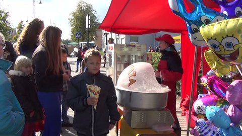 SIRVINTOS, LITHUANIA - SEPTEMBER 29: young vendor sell popcorn for children and other sweets in city market on September 29, 2013 in Sirvintos,Lithuania.