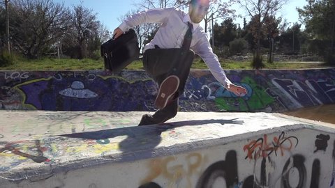 Businessman Doing Parkour. Jumping over a graffiti wall. Acrobatic getaway in slow motion. 