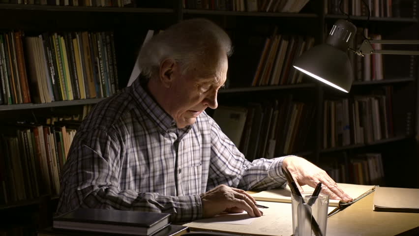 A gray-haired man copying data from the register to a blank sheet of paper