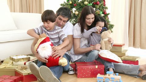 Parents and children opening Christmas presents at home. Footage in high definition Stock Video