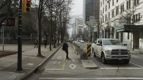 VANCOUVER- January 27, 2014: Foggy downtown Vancouver with skateboarder using bike lane near Hotel Vancouver