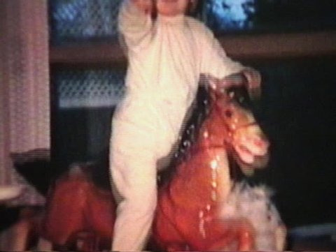 A little boy has fun riding his toy horse and then invites his friend Mr. Panda bear to come for a ride too. (Vintage 8mm film)