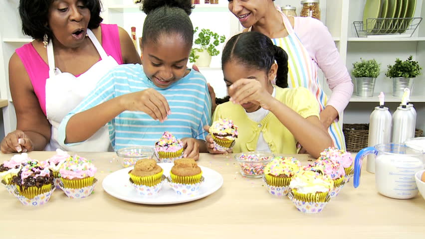 Young African American girls with mom grandmother enjoying making cakes together home kitchen - Young Girls Baking Kitchen Ethnic Mom Grandmother