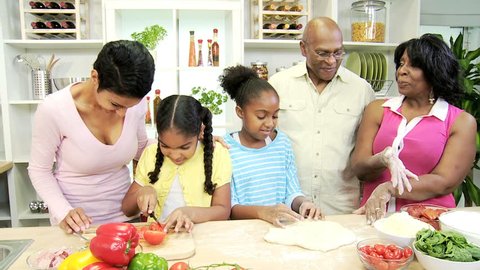 Young ethnic girls with mom in grandparents kitchen using pastry fresh vegetables to help prepare healthy lunch together - Ethnic Children Family Kitchen Mother Grandparents