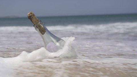 SLOW MOTION: Stranded bottle on the beach