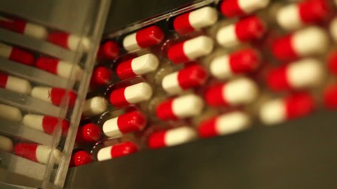 Drug Production. Pharmaceutical machinery for medicine production Pills. Shot ending in a blur defocus scene - ideal to put a text, logo or graphics on it.