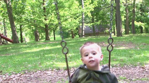 Small Child Swinging in Baby Swing