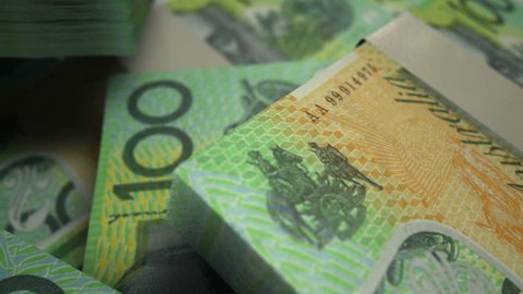 An extreme closeup pan across variously placed bundled wads of Australian dollar banknotes