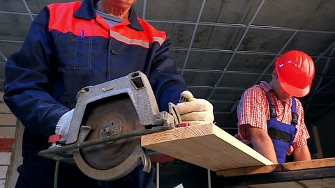 Happy group people builder with circular saw.