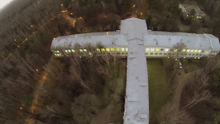 Edifice in shape of airplane among trees on Elk island at autumn evening. Aerial view