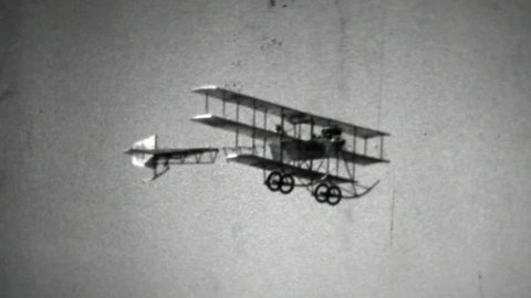An old black and white film of an old flying machine. A vintage Avro 1910 replica triplane propeller aircraft. Oldtime aviation vintage airplane. Early aeroplane technology.