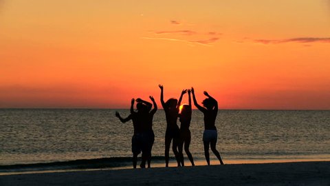 Group carefree boy girl teenagers casual beachwear enjoying beach party at sunset on vacation together shot on RED EPIC - Silhouetted College Friends Laughing Dancing Beach Party