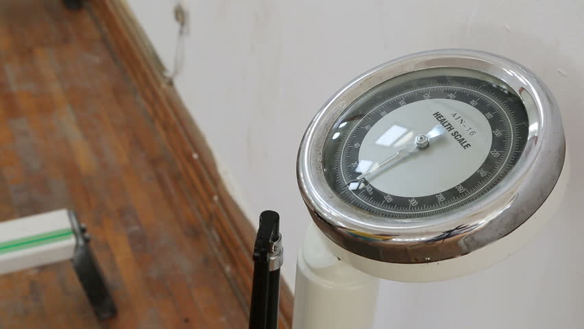 overweight woman is weighed on scales