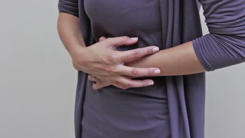 menstruation pain or stomach trouble, woman hand holding her belly, body closeup quarter view