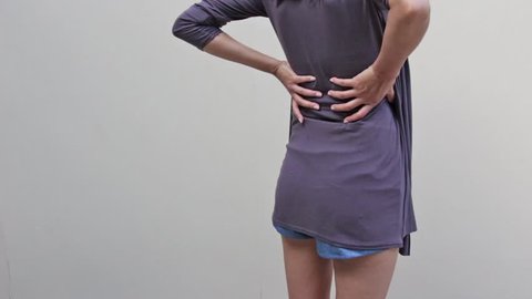 woman with backpain, spinal, waist, lower back problem, quarter view from rear