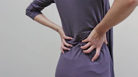 woman with backpain, spinal, waist, lower back problem, quarter view from rear closeup shot
