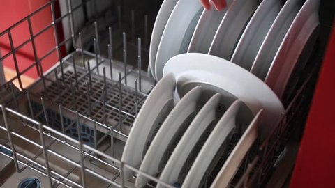 A woman unloading the dishwasher in the kitchen