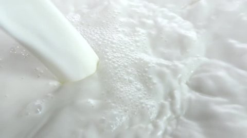 Pouring milk closeup. Milk Splesh Slow motion footage 240 fps. High speed camera shot 1080. Slowmo