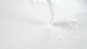 Pouring milk closeup. Milk Splash Slow motion footage 240 fps. High speed camera shot 1080. Slowmo