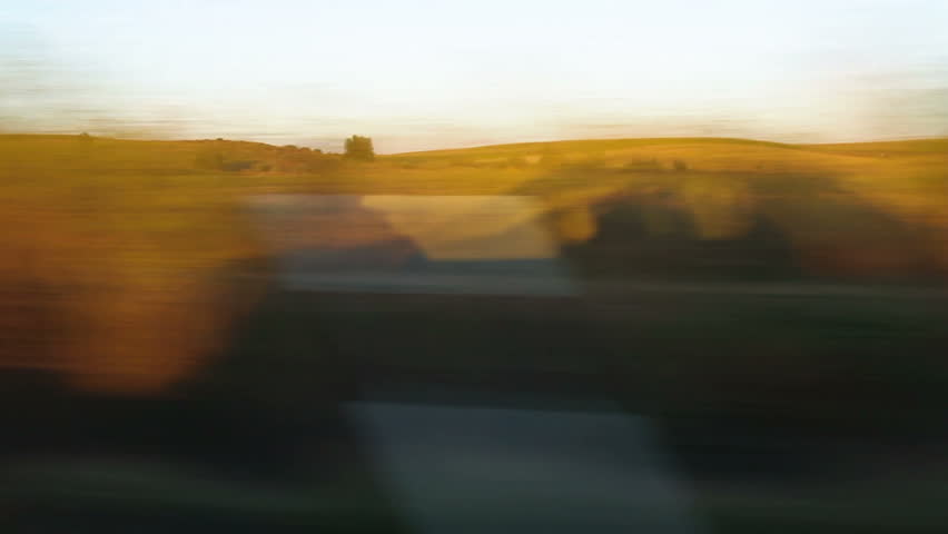 Traveling Shadow side of a moving car at sunset on background of cultivated fields and dirt road (Two different frames)  Royalty-Free Stock Footage #6027422