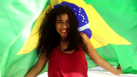 Brazilian girl with flag at the beach in slow motion