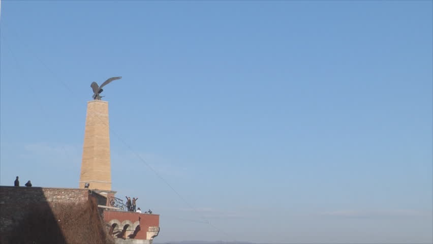 Zoom out of a castle at a background of mountainous landscape