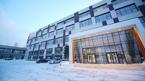 Facade with big glass entrance of business center at winter snowy day