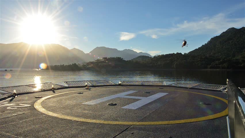 Low angle of a helicopter landing on a ship helipad at sunrise near Chait\xED\xA9n in Northern Patagonia in Chile. Royalty-Free Stock Footage #6032717